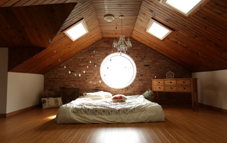 Lovely bright light shining through skylights and round window in an attic room - space planning